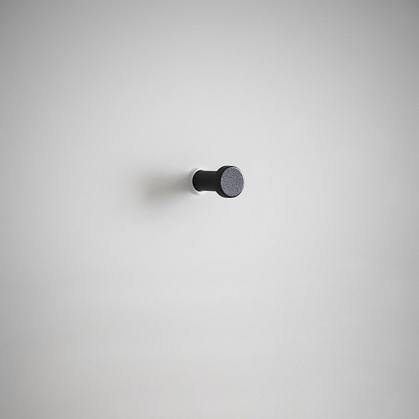 Schwarzer Wandhaken auf weißem Hintergrund, seitliche Perspektive