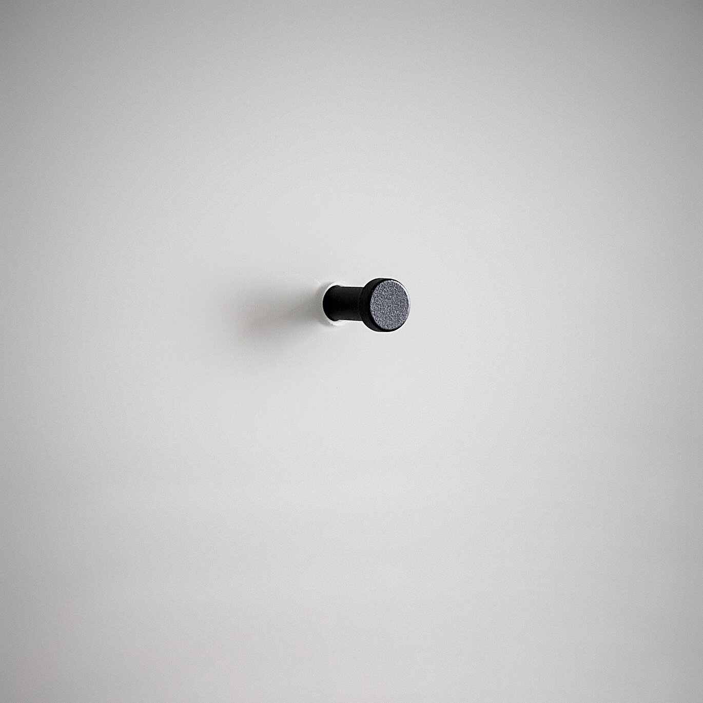 Schwarzer Wandhaken auf weißem Hintergrund, seitliche Perspektive