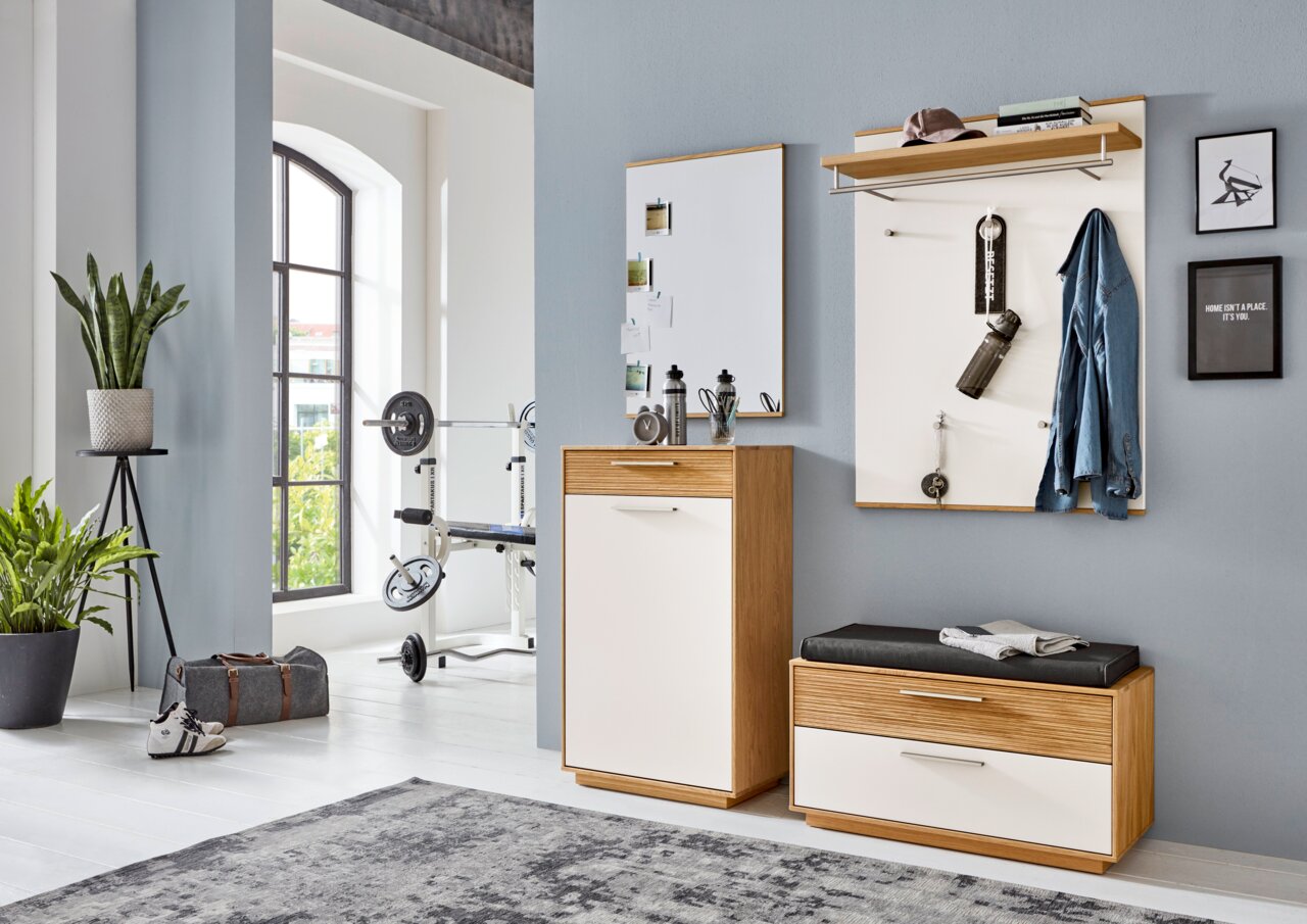 Moderne halmeubelset in eikenlook en wit met spiegelkast, wandkapstok met hoedenplank en zitbank met lade, gefotografeerd frontaal in een lichte hal/woonruimte