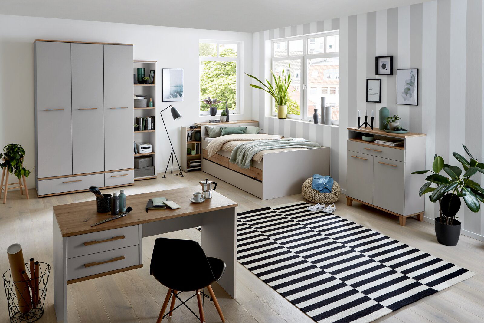 Modernes Jugendzimmer mit Drehtürenschrank, Schreibtisch, Bett und Regalen in heller, freundlicher Atmosphäre. Perspektive: Frontalansicht des gesamten Zimmers.