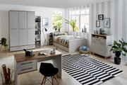 Modernes Jugendzimmer mit Drehtürenschrank, Schreibtisch, Bett und Regalen in heller, freundlicher Atmosphäre. Perspektive: Frontalansicht des gesamten Zimmers.