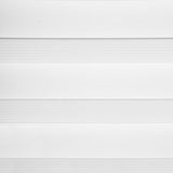 Nahaufnahme eines weißen Doppelrollos mit abwechselnden transparenten und blickdichten Streifen.