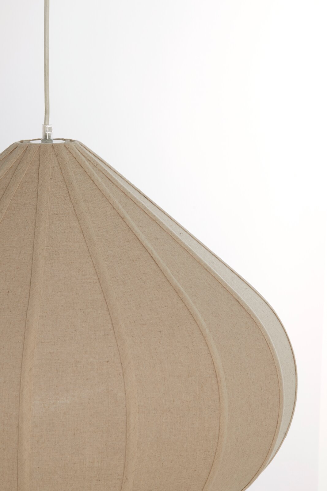 Nahaufnahme einer beige Hängeleuchte mit textiler Oberfläche, seitliche Perspektive
