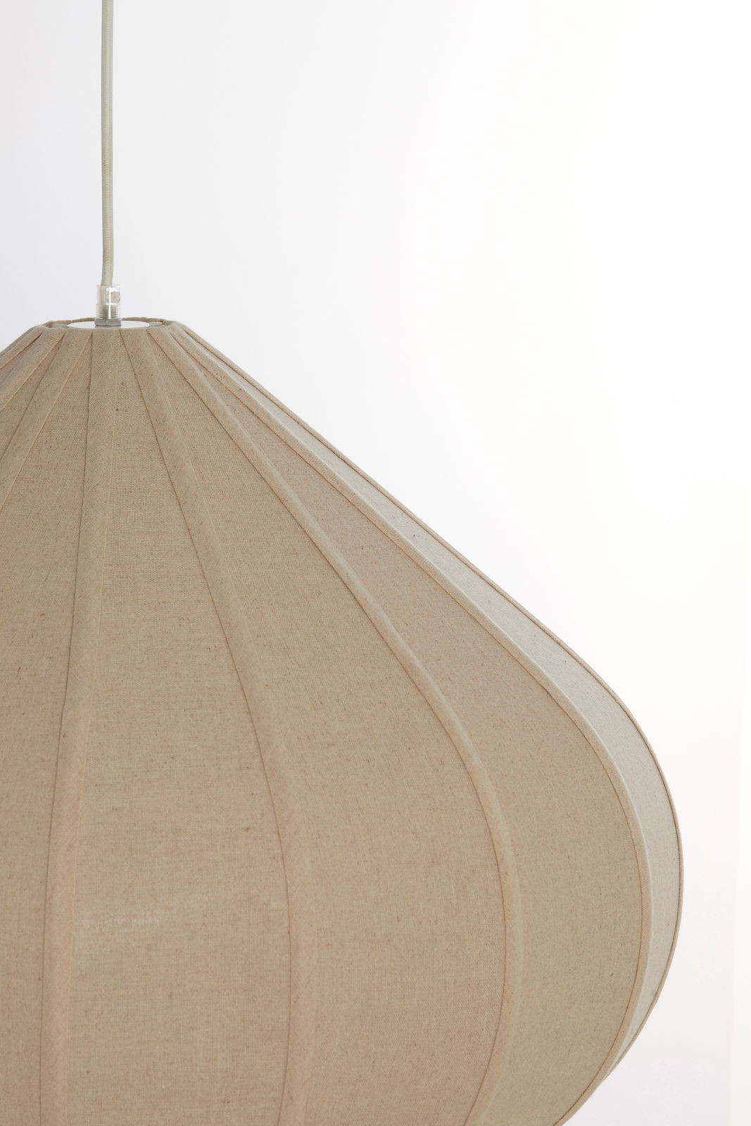Nahaufnahme einer beige Hängeleuchte mit textiler Oberfläche, seitliche Perspektive