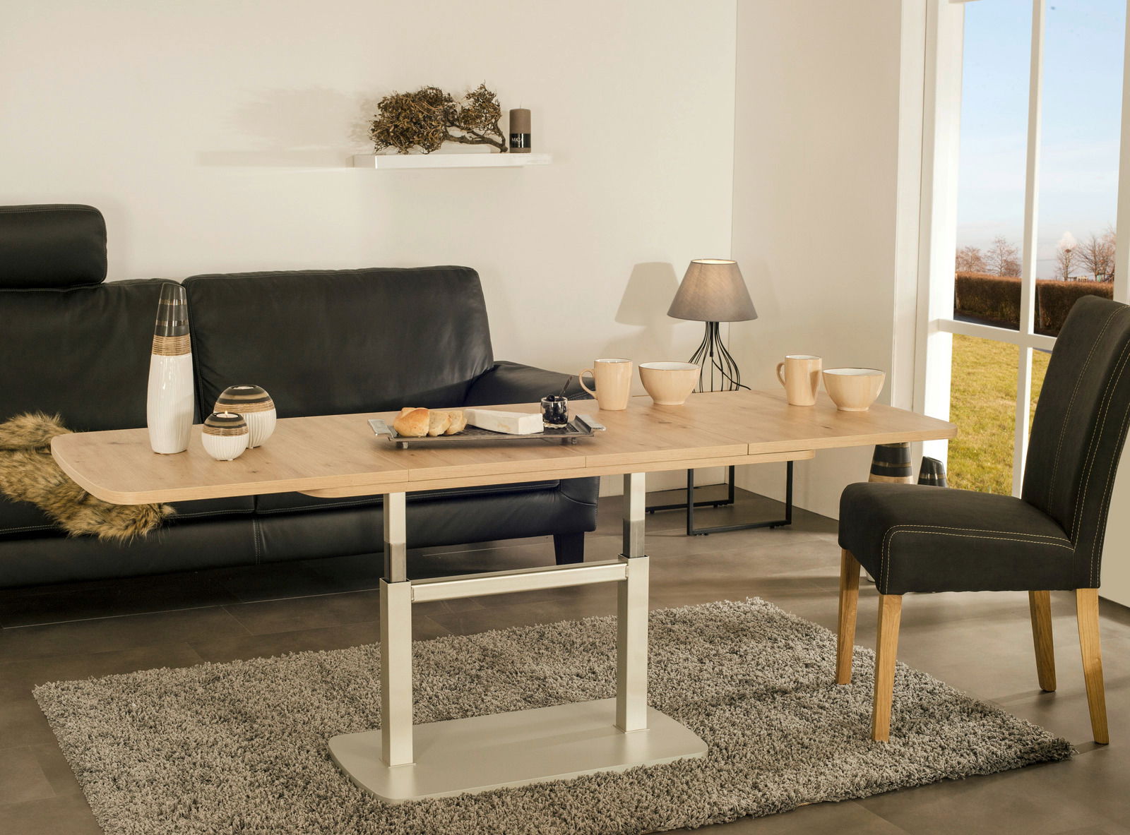 Moderner Couchtisch in heller Holzoptik mit Metallgestell, seitliche Perspektive, dekoriert mit Geschirr und Dekorationsartikeln, in einem stilvollen Wohnzimmer.