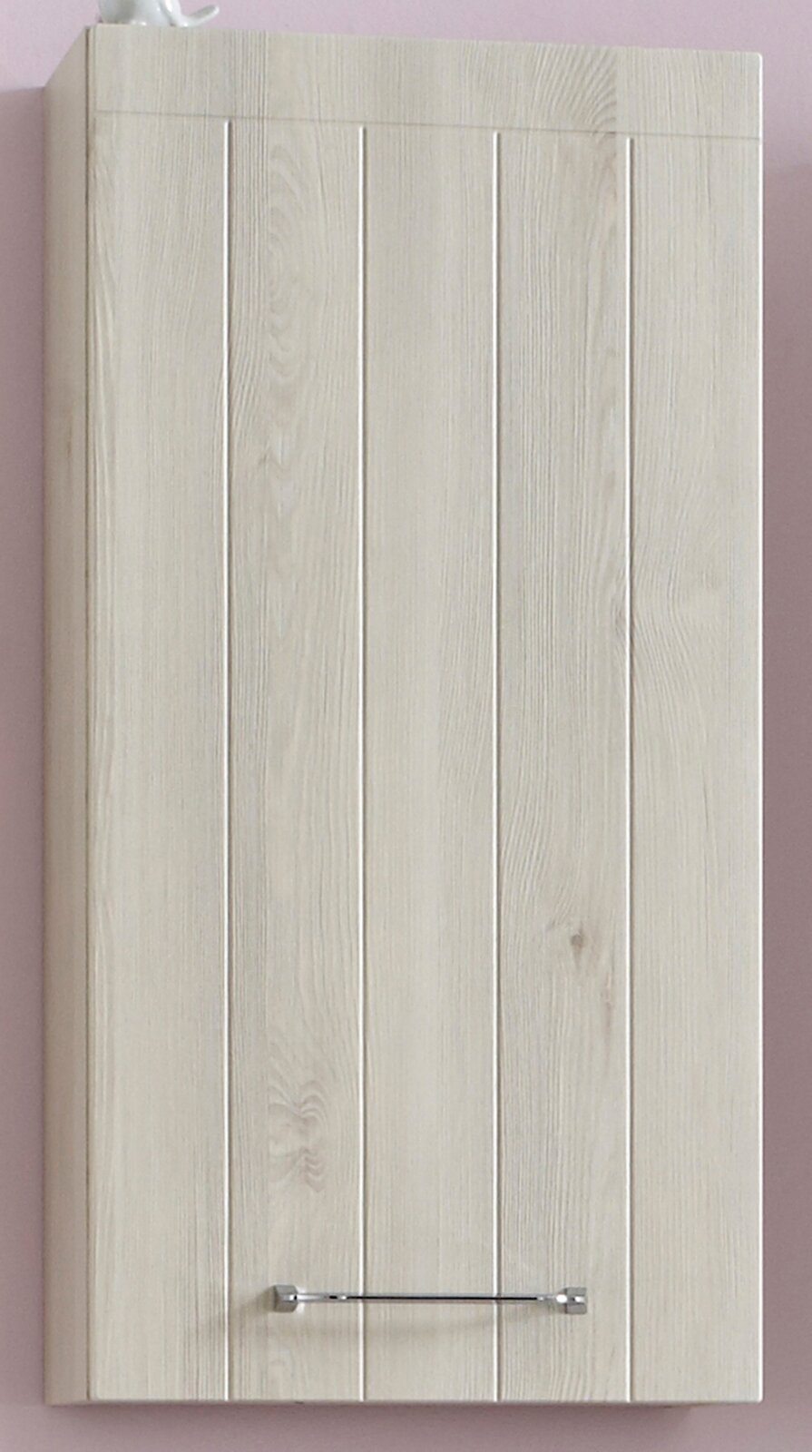 Vooraanzicht van een lichte houten badkamerkast met verticale panelen en een verchroomde handgreep tegen een roze muur