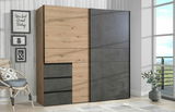 Moderner Schwebetürenschrank WINN2 in Holz- und Betonoptik, seitliche Perspektive, in einem hellen Raum mit Dekoration.