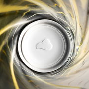 Blick von oben in ein gelbes Trinkglas mit Twist-Design, 300ml, mit Herzform am Boden.