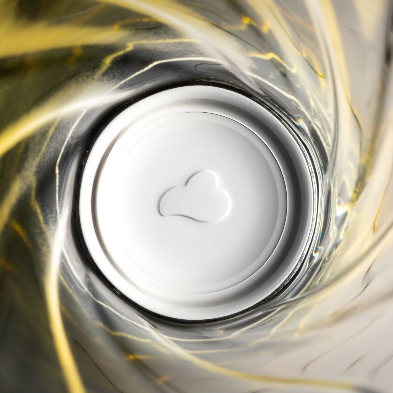 Blick von oben in ein gelbes Trinkglas mit Twist-Design, 300ml, mit Herzform am Boden.