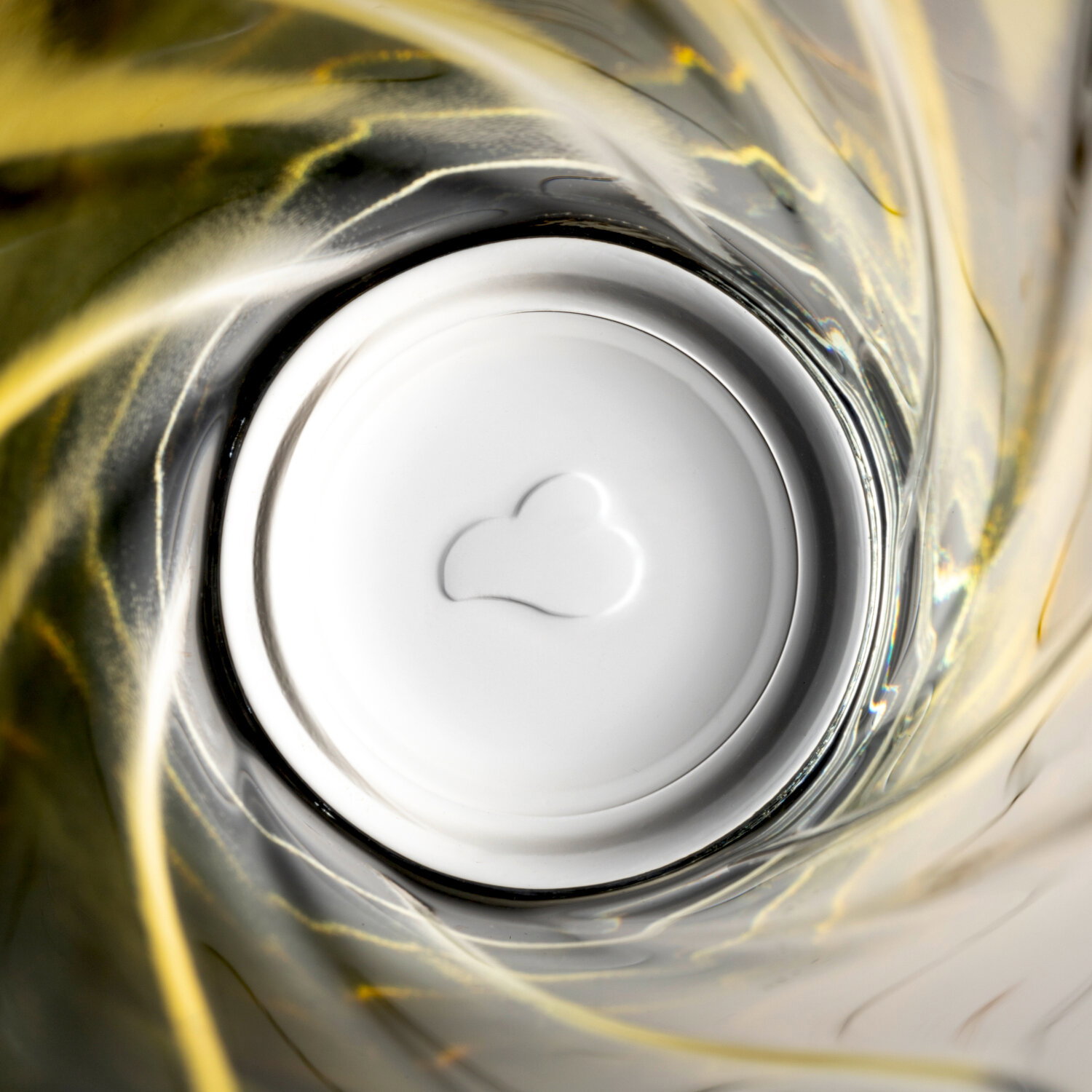 Blick von oben in ein gelbes Trinkglas mit Twist-Design, 300ml, mit Herzform am Boden.