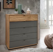 Moderne Schubkastenkommode aus Holz mit grauen Schubladen, dekoriert mit Pflanzen und Vasen, seitliche Perspektive