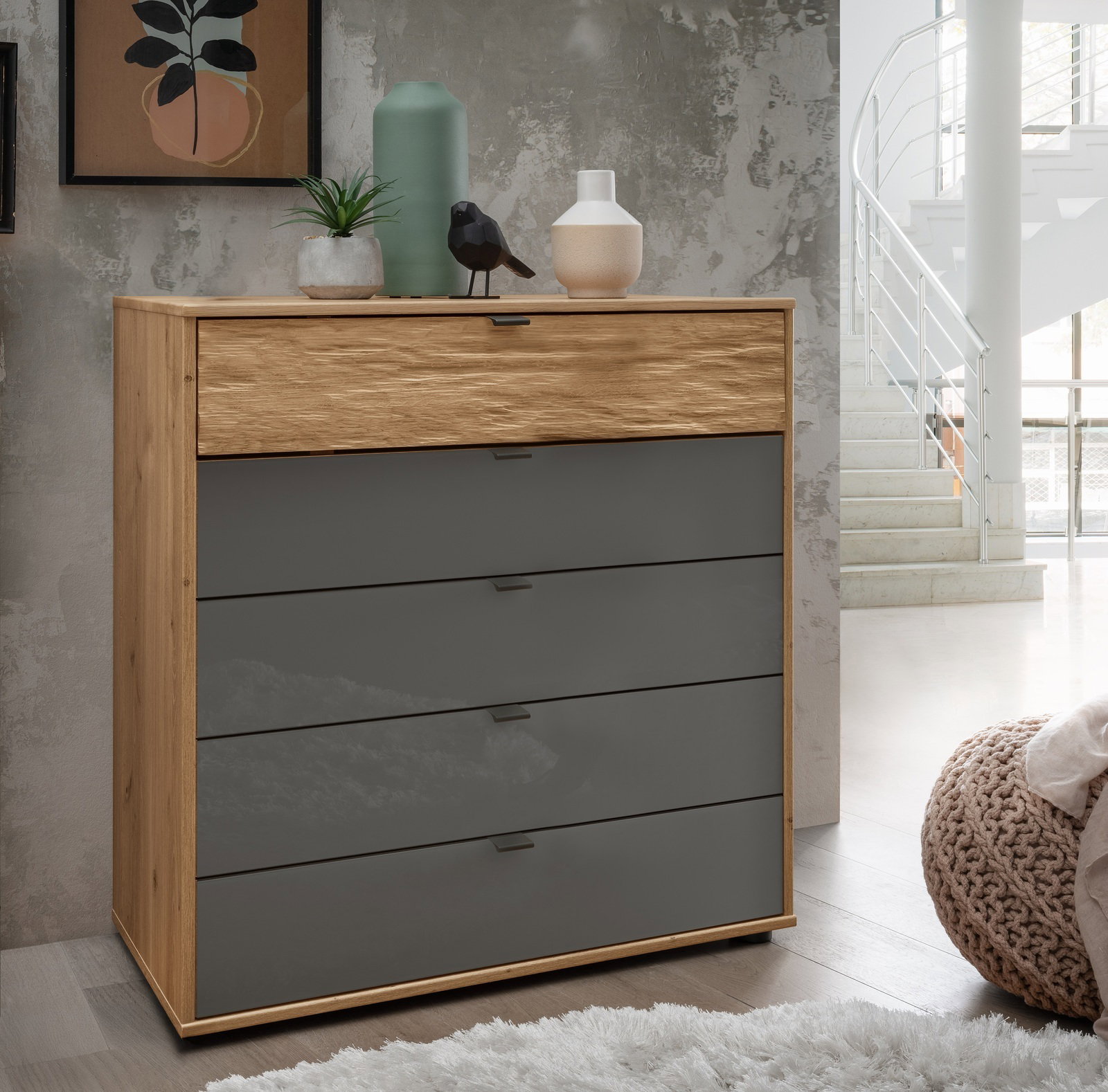 Moderne Schubkastenkommode aus Holz mit grauen Schubladen, dekoriert mit Pflanzen und Vasen, seitliche Perspektive