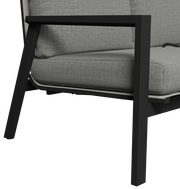 Nahaufnahme einer modernen Gartenbank mit schwarzem Metallrahmen und grauem Polster, seitliche Perspektive