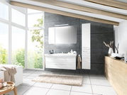 Moderne badkamercombinatie met witte wastafel en spiegelkast, aan de zijkant geflankeerd door een hoge kast, in een lichte badkamer met grote ramen en een houten balkenplafond, gezien van voren.