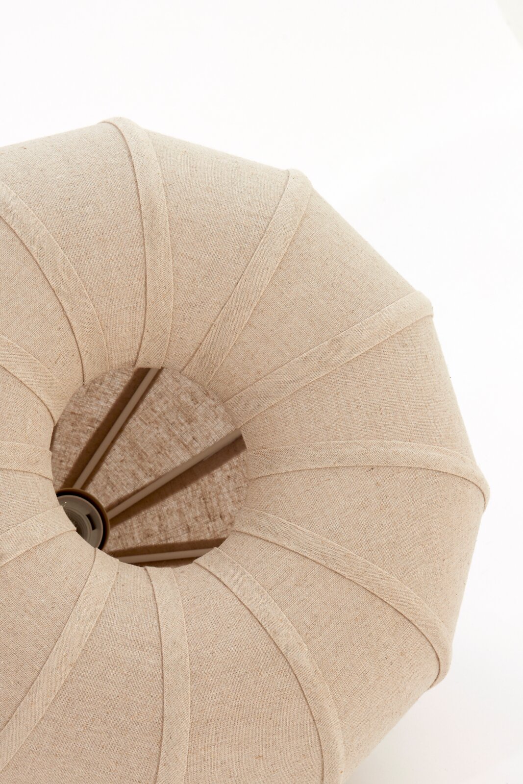 Bovenaanzicht van een beige hanglamp met stoffen bekleding en radiale steunen.
