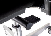 Nahaufnahme eines Hebels unter einem Chefsessel, der zur Höhenverstellung dient.