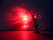 LED-sierlamp in de vorm van een astronaut die een rode lichtstraal op de muur projecteert. Aanzicht van rechtsachter.