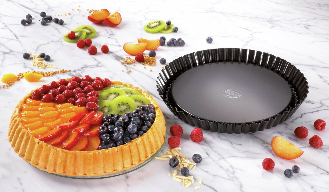 Dr. Oetker Obstkuchenform 28cm BACKFREUDE Obstkuchenform 28cm BackFreude, seitliche Perspektive, neben einem dekorierten Obstkuchen mit frischen Früchten auf einem Marmortisch.