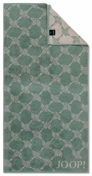 Grünes Handtuch mit geometrischem Muster und JOOP!-Logo, aus der Vogelperspektive fotografiert.
