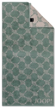 Grünes Handtuch mit geometrischem Muster und JOOP!-Logo, aus der Vogelperspektive fotografiert.