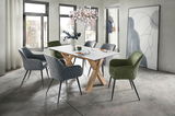 Moderner Esstisch mit weißer Tischplatte und Holzbeinen, umgeben von gepolsterten Stühlen in Grau und Grün, in einem hellen Raum mit großen Fenstern, aus seitlicher Perspektive.