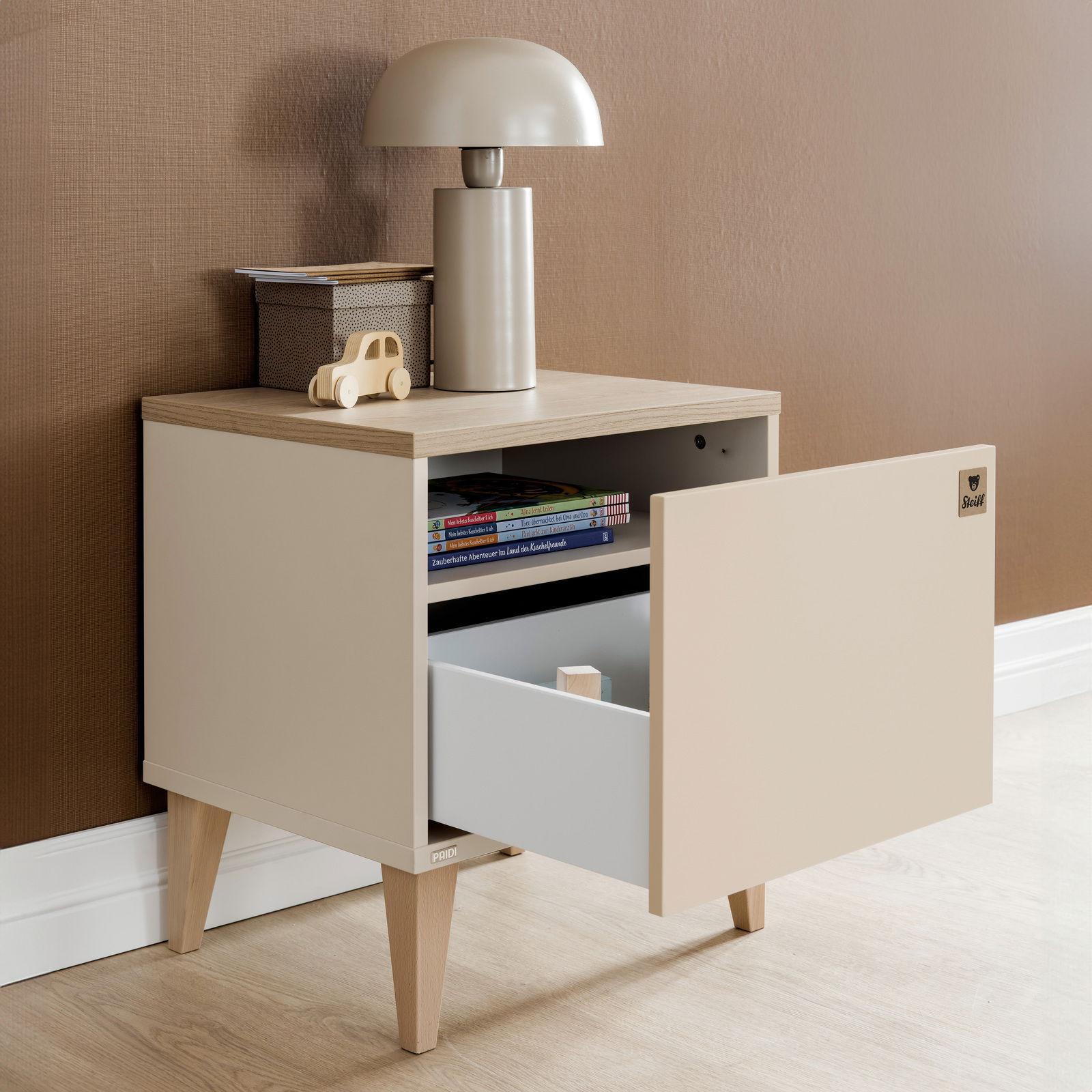 Nachtkonsole mit offenem Schubfach, Bücher und Dekoration darauf, seitliche Perspektive