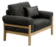 Gevoerde loungestoel met donkergrijze gemêleerde stoffen bekleding, licht houten frame en zwart kussen, vrijstaand in schuin vooraanzicht vanaf links
