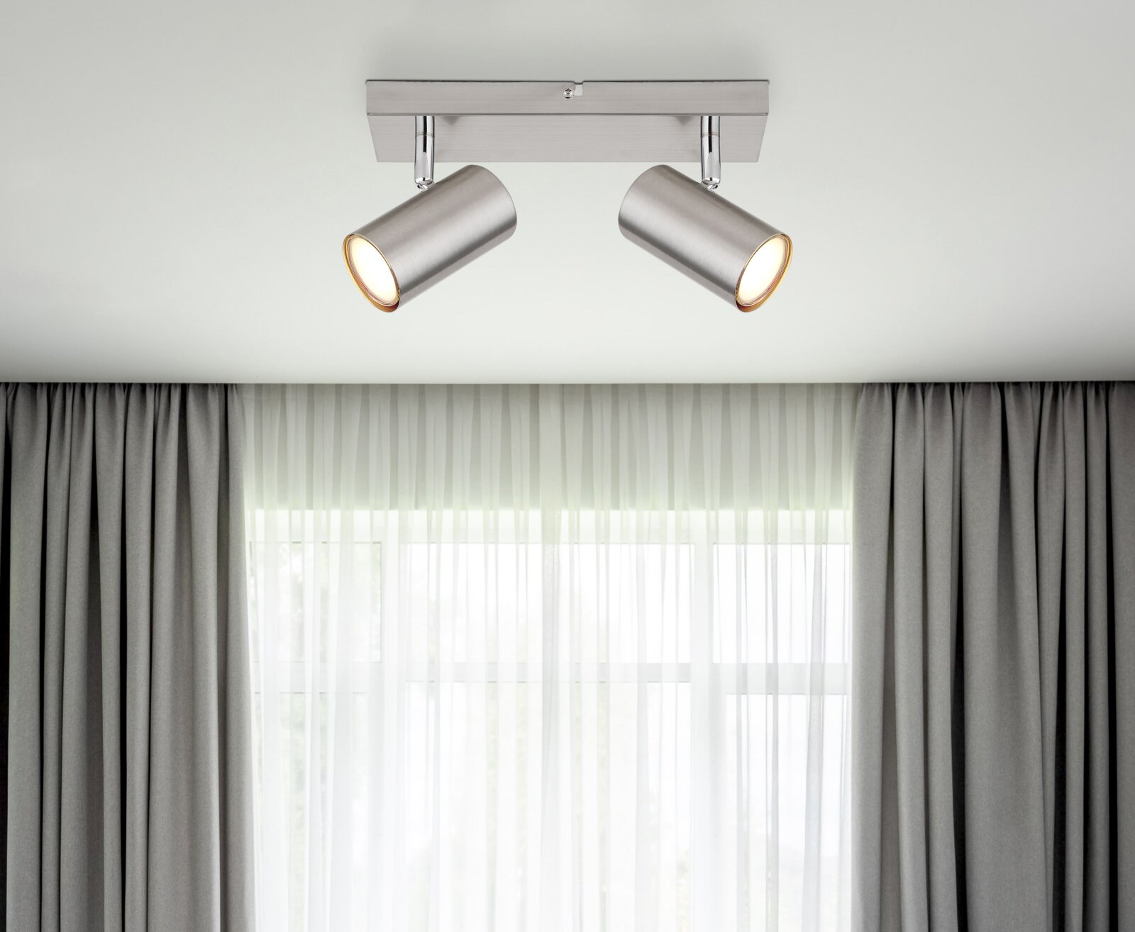 Moderne plafondspots van geborsteld metaal met twee verstelbare lampen, gezien van onderaf.
