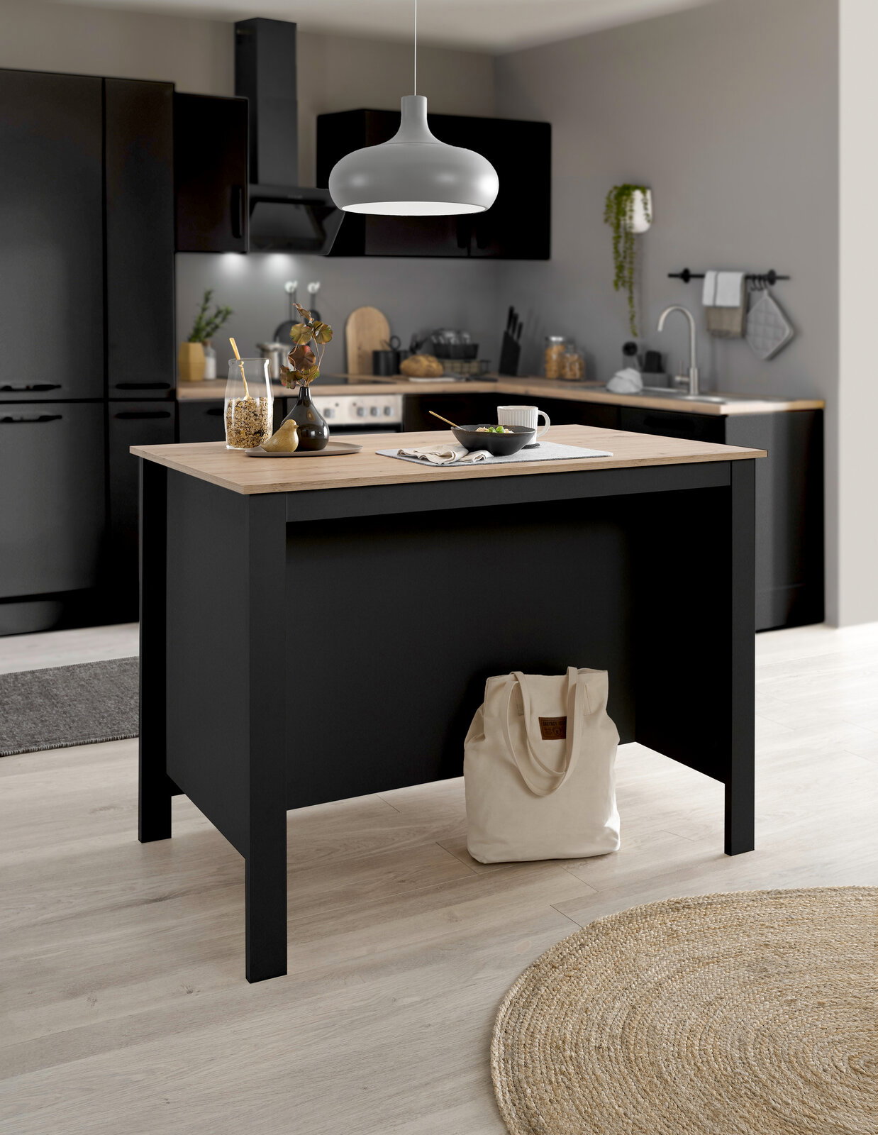 Moderne Kücheninsel in einer stilvollen Küche, frontal betrachtet, mit Holzarbeitsplatte und schwarzem Korpus, dekoriert mit Geschirr und Pflanzen.