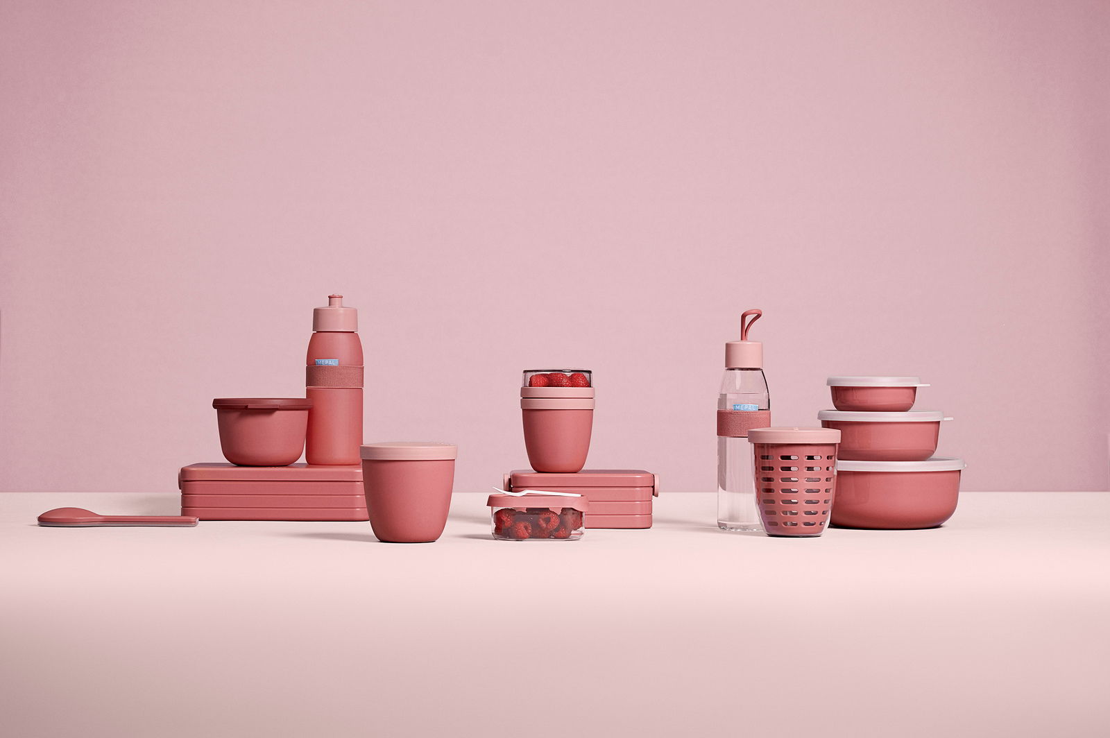 Mepal Fruitpot Vivid mauve ELLIPSE Rosa Fruchtbehälter in elliptischer Form, umgeben von weiteren rosa Küchenutensilien, seitliche Perspektive