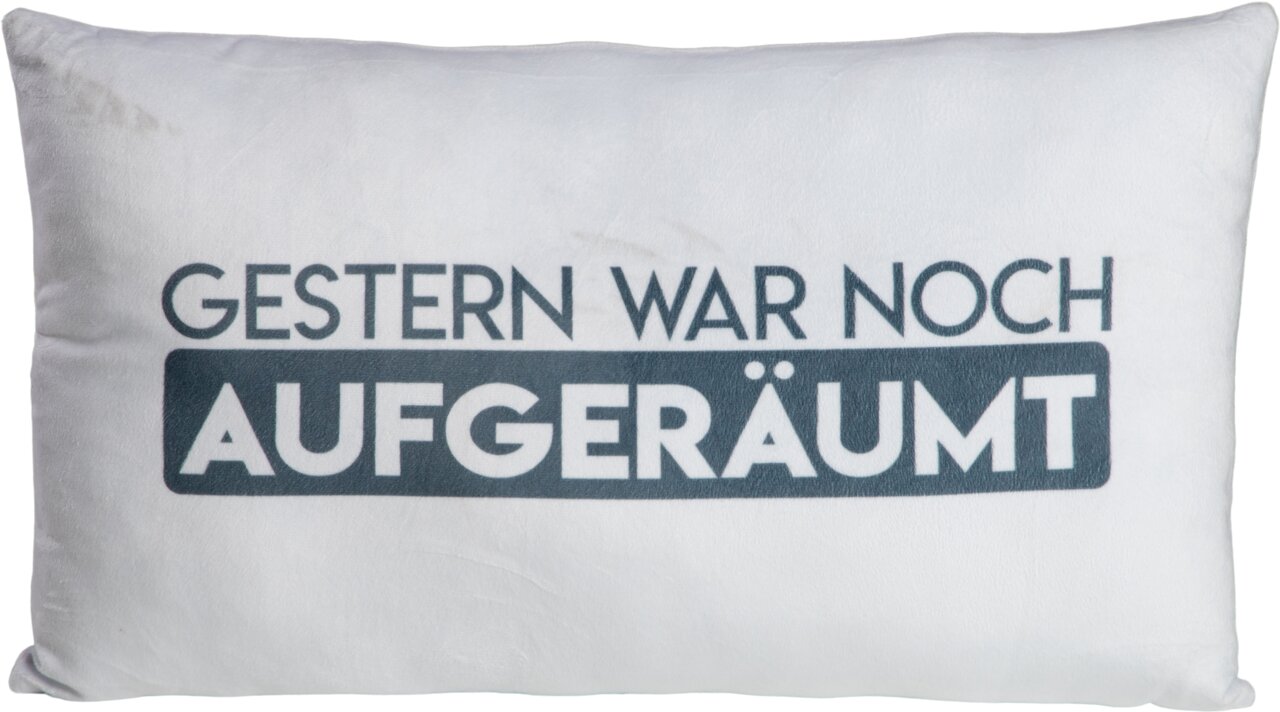Dekokissen mit dem Spruch 'GESTERN WAR NOCH AUFGERÄUMT', frontal fotografiert.