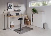 Moderner E-Schreibtisch in einem stilvollen Büro mit Blick von vorne, ausgestattet mit Laptop, Pflanzen und Regalen.
