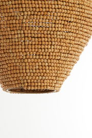 Nahaufnahme einer Hängeleuchte mit einer Oberfläche aus kleinen, runden Holzperlen, von unten betrachtet.