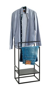 Schwarzer Metall-Kleiderständer mit Ablage, vorne aus der Frontalansicht; oben hängt ein hellblaues Hemd, darunter liegt eine gefaltete blaue Jeans auf der Stange.