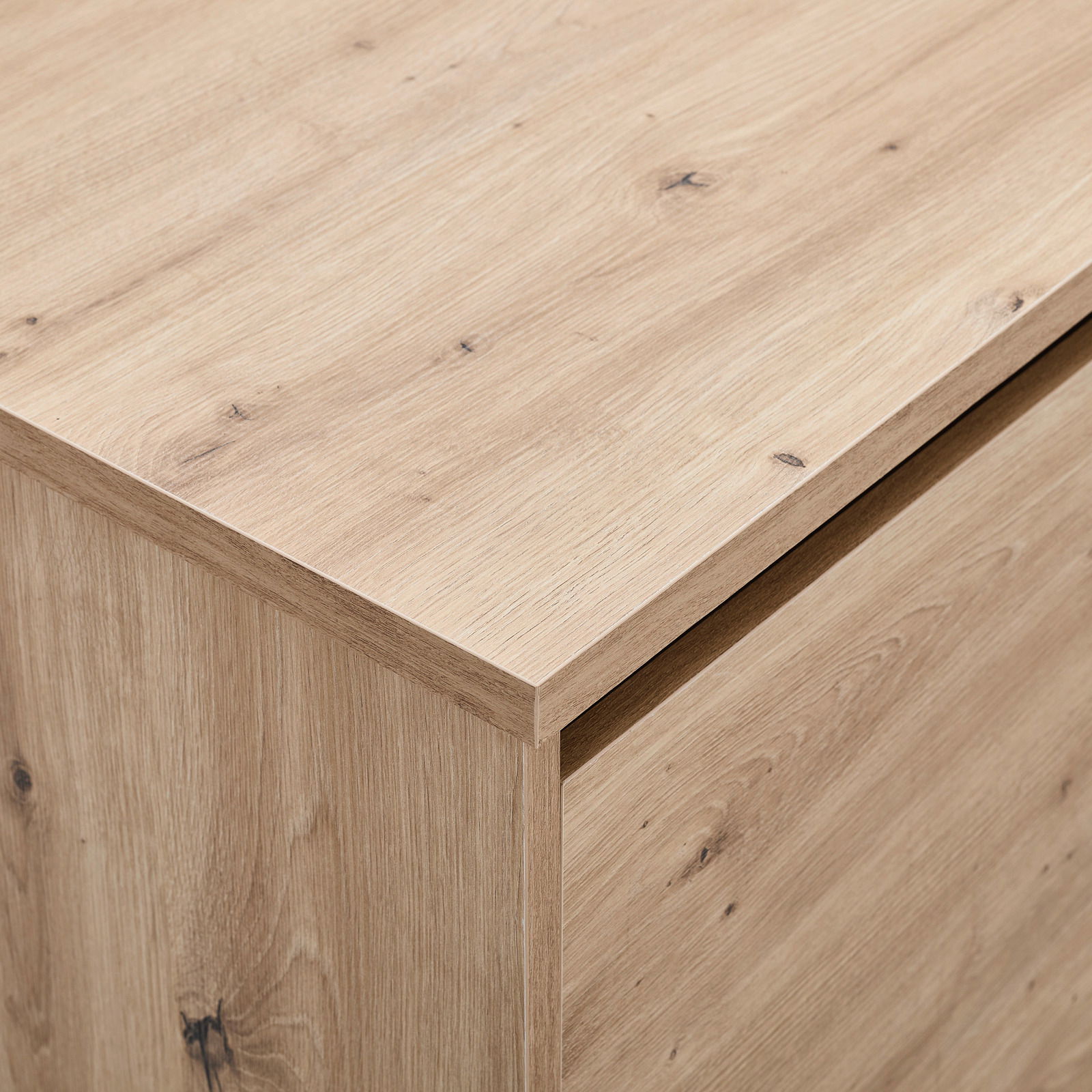 Nahaufnahme eines TV-Lowboards aus hellem Holz mit sichtbarer Maserung, Perspektive von oben.