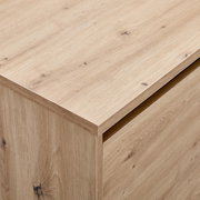 Nahaufnahme eines TV-Lowboards aus hellem Holz mit sichtbarer Maserung, Perspektive von oben.