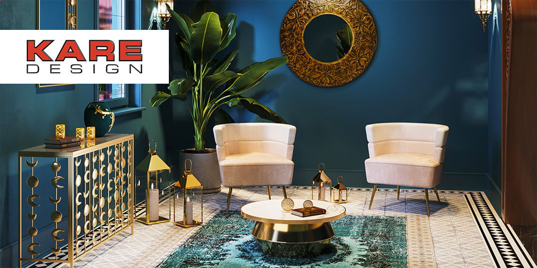 Ein eleganter Raum mit zwei Samtsesseln, goldenen Deko-Elementen und einem runden Spiegel an der Wand.