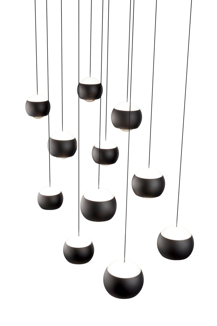 Mehrere schwarze Pendelleuchten in Kugelform, von der Decke hängend, aus der Perspektive von unten betrachtet.