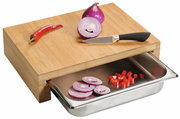 Schneidebrett aus Holz mit integrierter Auffangschale, darauf liegen eine geschnittene Zwiebel, ein roter Chili und ein Messer. Perspektive von schräg oben.