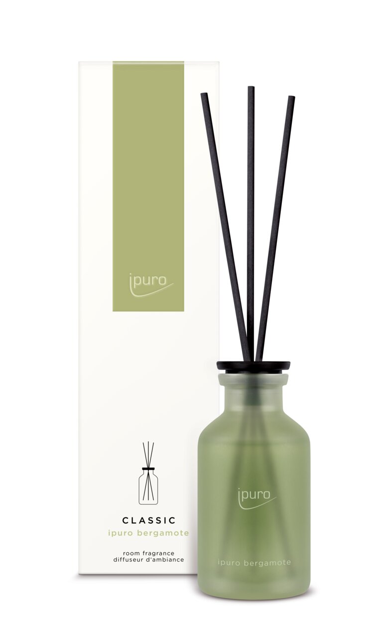 Grüner Raumduft-Diffuser mit schwarzen Stäbchen und passender Verpackung, Frontalansicht