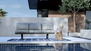 3-Sitzer Loungeelement in moderner Außenumgebung, frontal betrachtet, mit grauen Kissen auf einem blauen Teppich am Pool.