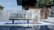 3-Sitzer Loungeelement in moderner Außenumgebung, frontal betrachtet, mit grauen Kissen auf einem blauen Teppich am Pool.