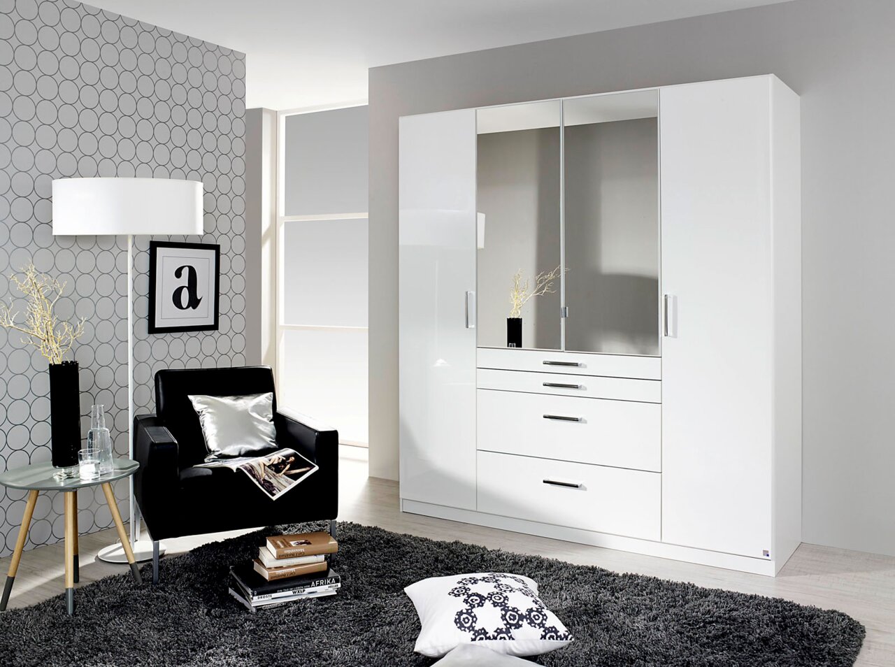 Moderner, weißer Drehtürenschrank mit vier Türen, zwei davon mit Spiegeln, in einem stilvoll eingerichteten Raum aus der Frontalperspektive.