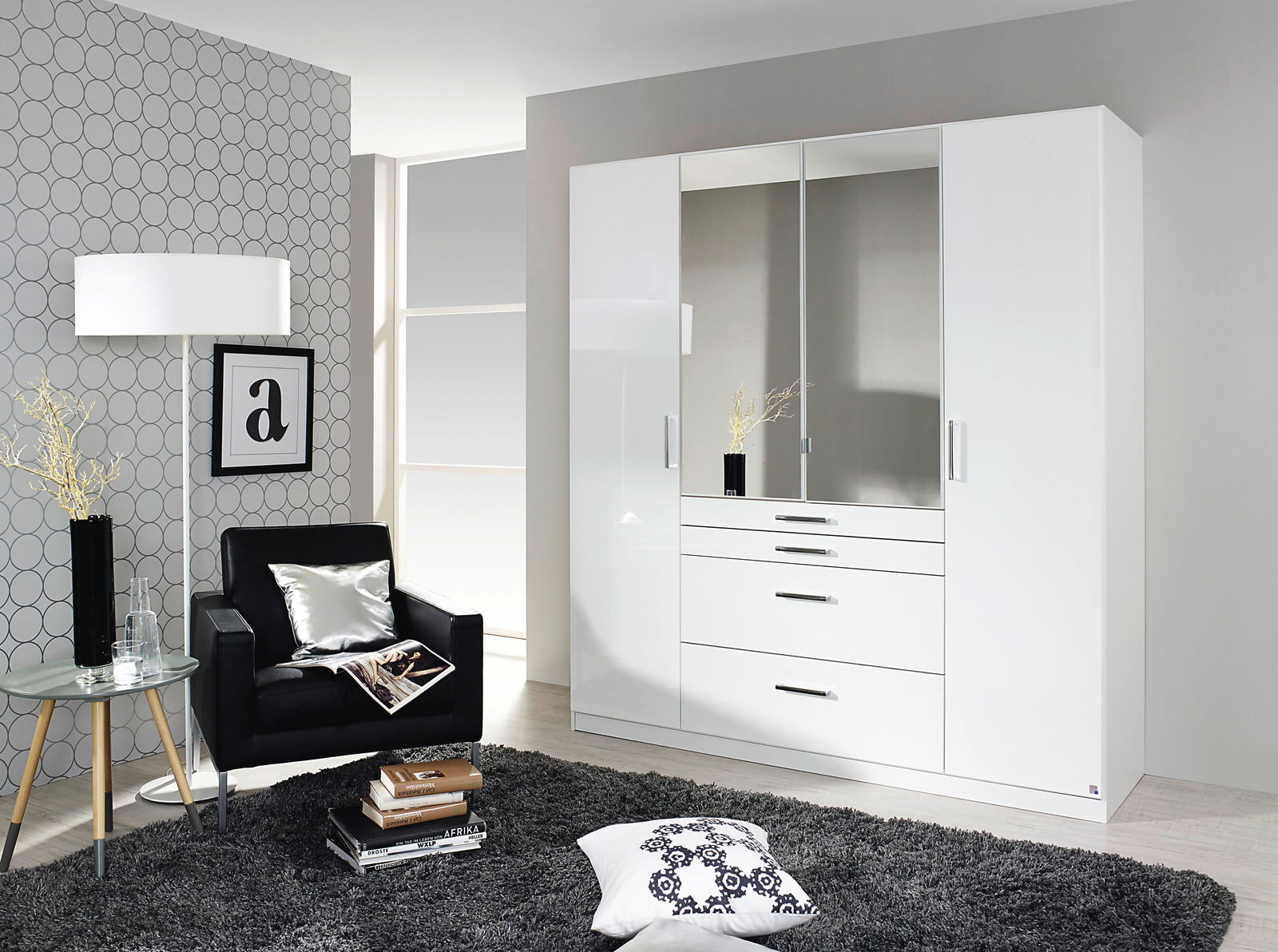Moderner, weißer Drehtürenschrank mit vier Türen, zwei davon mit Spiegeln, in einem stilvoll eingerichteten Raum aus der Frontalperspektive.