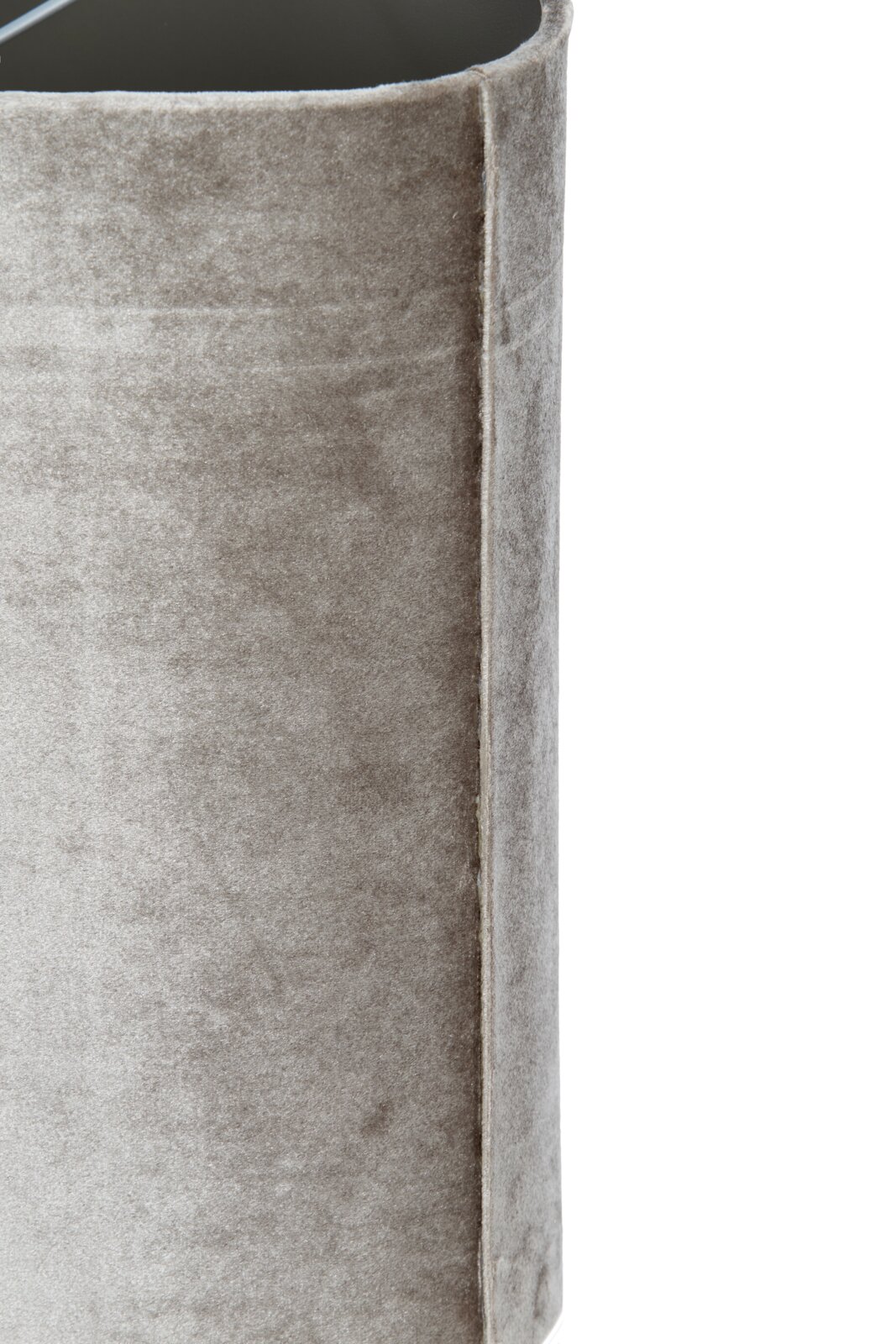 Detailopname vanuit schuin zijaanzicht van een taupekleurig, fluweelzacht bekleed meubel met afgeronde bovenrand en verfijnde naadafwerking