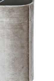 Detailopname vanuit schuin zijaanzicht van een taupekleurig, fluweelzacht bekleed meubel met afgeronde bovenrand en verfijnde naadafwerking