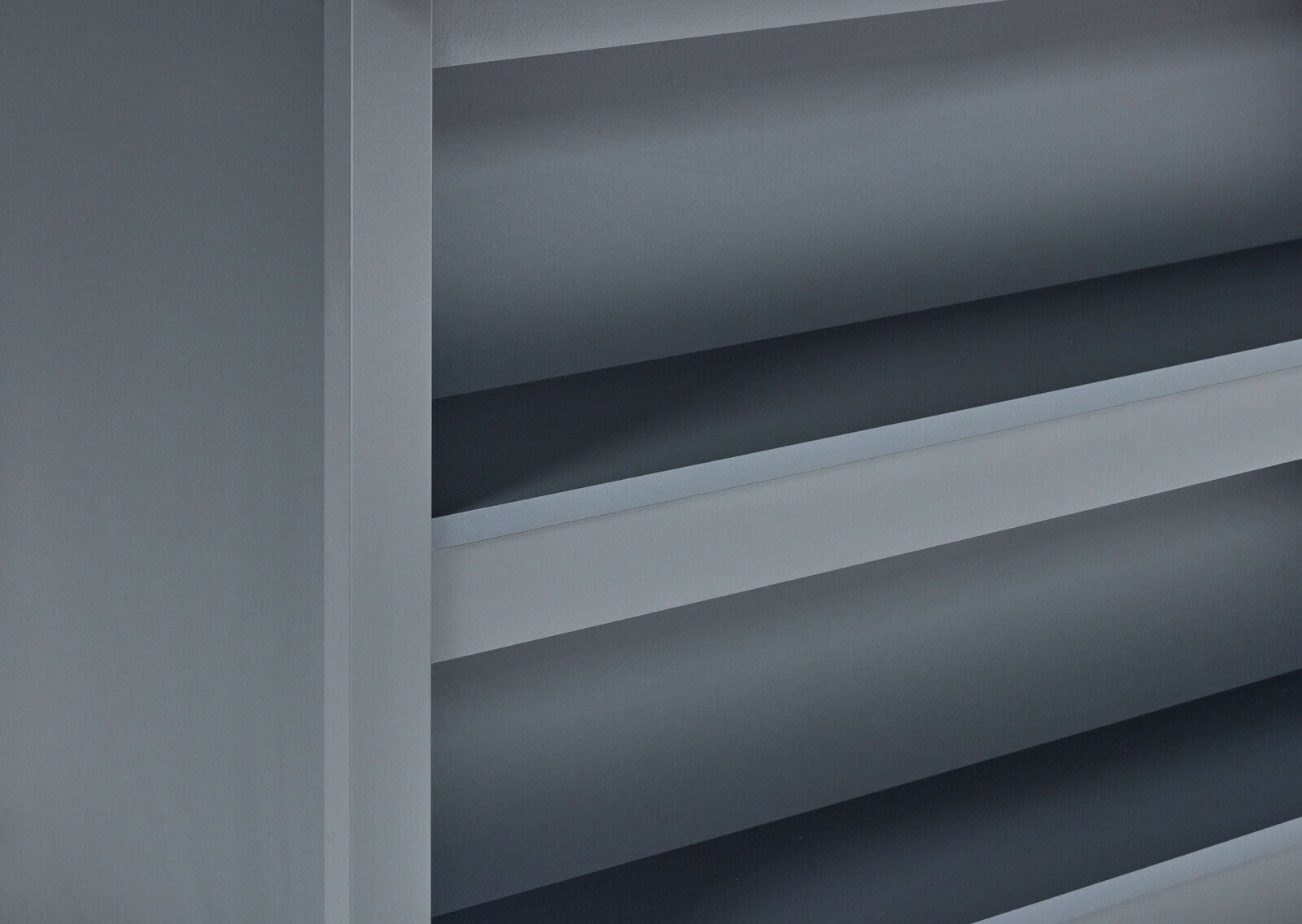 Detailansicht einer grauen Kücheninsel mit Regalfächern von der Seite