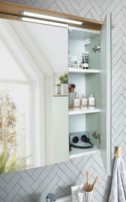 Moderner Spiegelschrank mit geöffneter Tür, der Innenraum zeigt Regale mit Pflegeprodukten und Steckdosen, seitliche Perspektive.