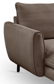 Detailaufnahme eines braunen Cord-Sofas mit breiter Armlehne, Kedernaht und schwarzem Fuß, schräg von vorne links fotografiert