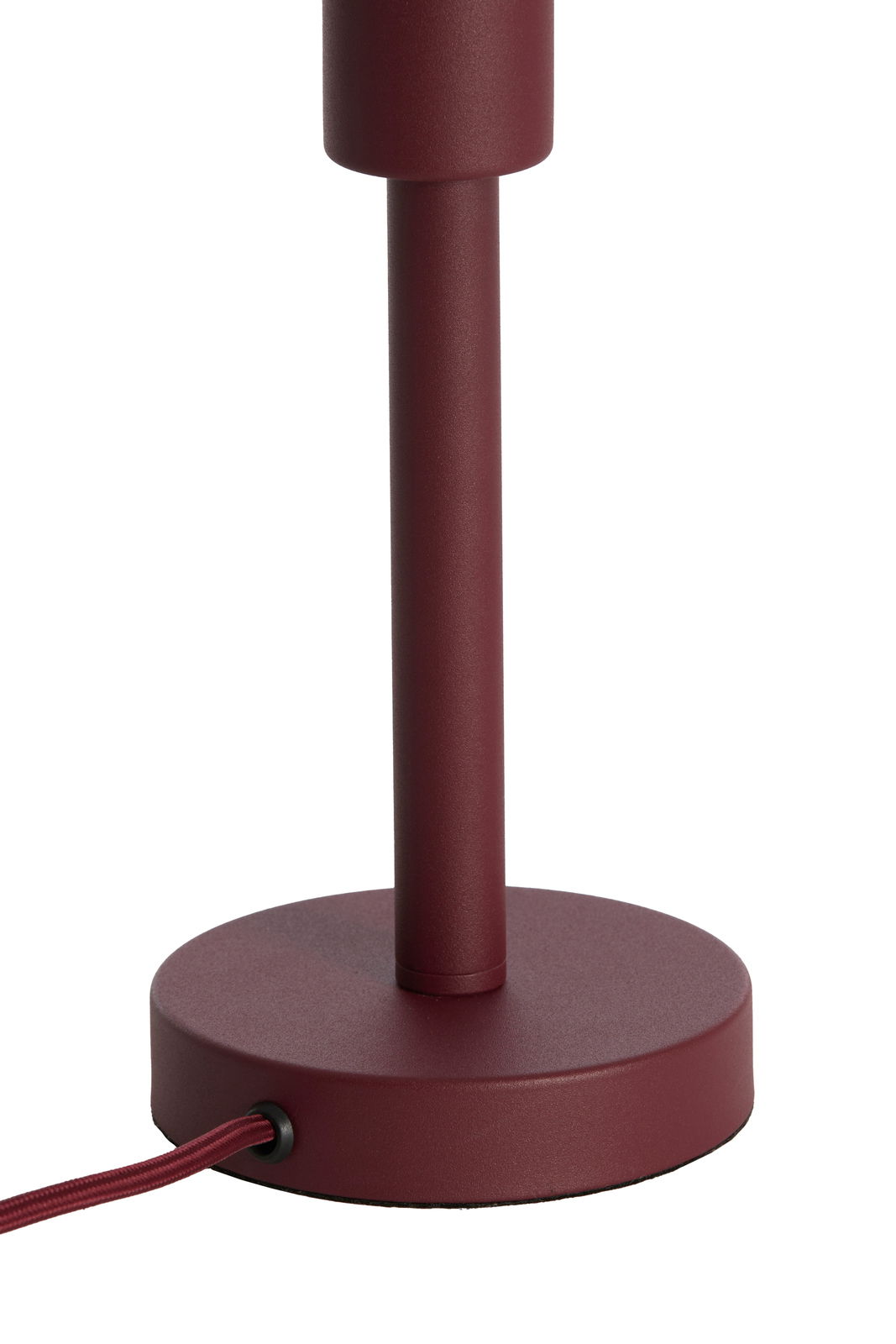 Nahaufnahme eines weinroten Lampenfußes mit rundem Sockel und Kabel, seitliche Perspektive.